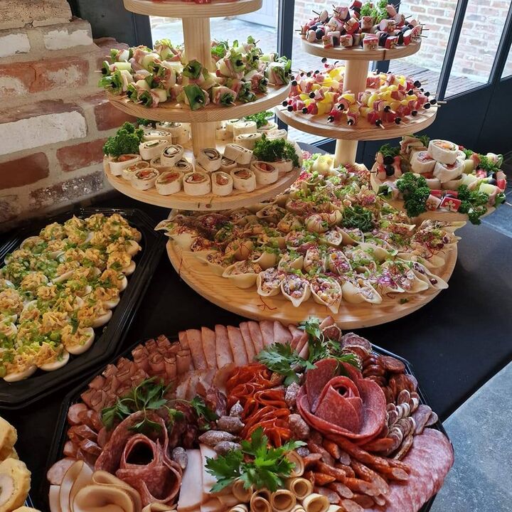 Buffet van Catering bij Natalia: houten etagères met wraps en hapjes, gevulde eieren en een schotel vleeswaren.