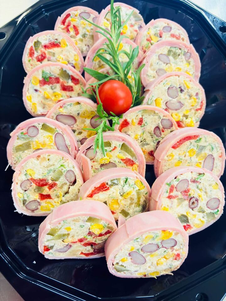 Hamrolletjes gevuld met groentesalade, op een schotel met rozemarijn.